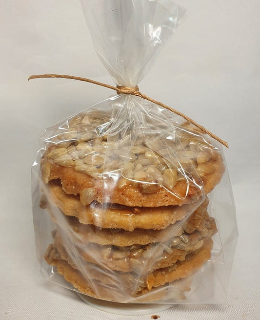 Biologischer Butterkuchen mit Sonnenblumenkernen und Honig, 150 g, auf einem Teller, frisch und goldbraun gebacken.